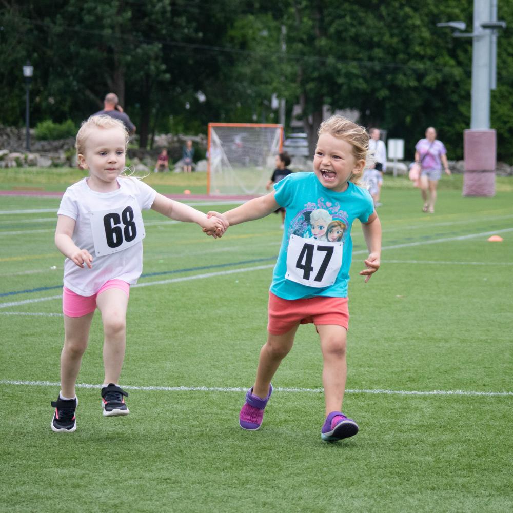 Two runners give each other a helping hand during the Marion Mile in June. Photo by Sawyer Smook-Pollitt